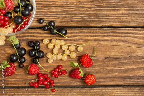 Assorted berries on wooden table background with copy space. Foods rich in vitamins and antioxidants. Healthy lifestyle.