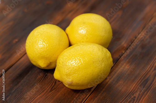 three lemons on a wooden background