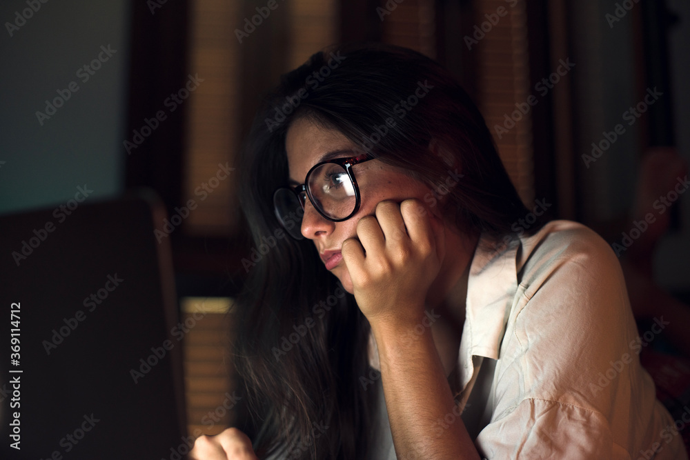 Woman at night working on laptop Woman at night working on laptop