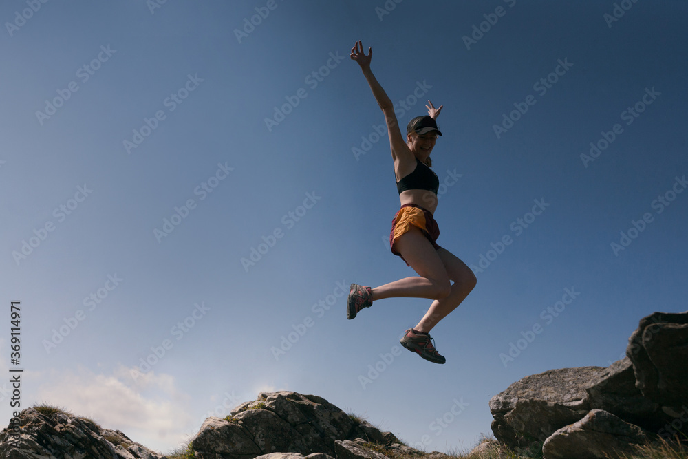 girl joyfully jumping from a stone against the sky girl joyfully jumping from a stone against the sky
