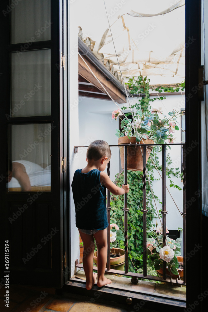 Little kid looking at the street from a balcony Little kid looking at the street from a balcony