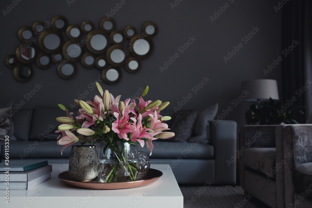 Pink lilies in a glass vase on the coffee table in a modern living toom