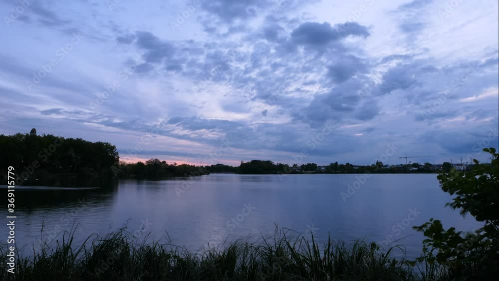 Time lapse of cumulus clouds over a Lake. Beautiful landscape with water and silhouette of vegetation. Wind in the foreground. Time lapse of cumulus clouds over a Lake. Beautiful landscape with water and silhouette of vegetation. Wind in the foreground.