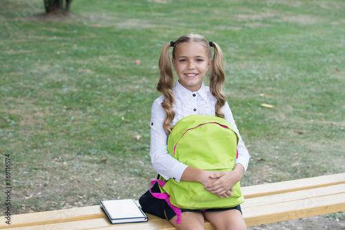 Schoolgirl with backpack relax outdoors, when claases over concept photo