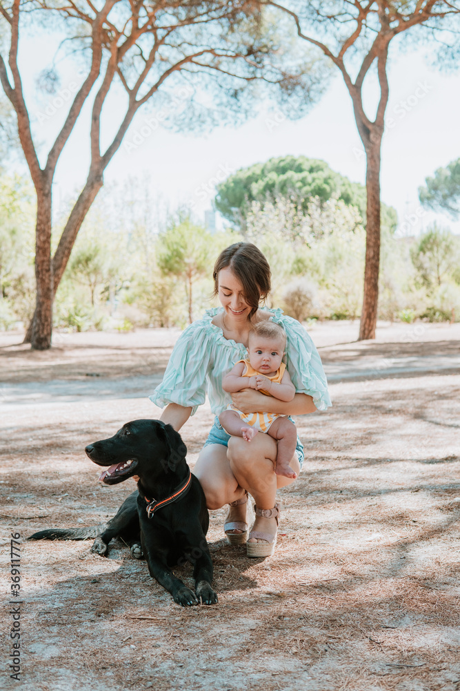 Mom with newborn baby and dog in park Mom with newborn baby and dog in park