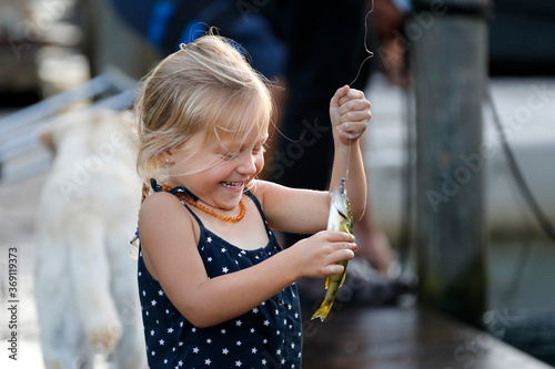 little girl holding a fish.