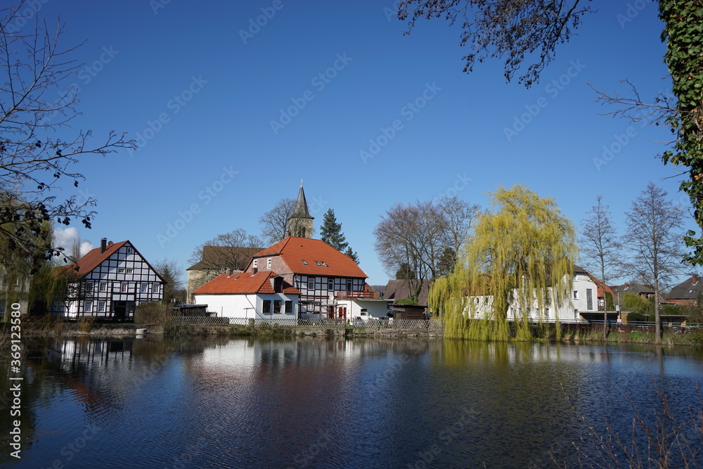 Spiegelung von Häusern im Wasser an einem Teich in einem Ort