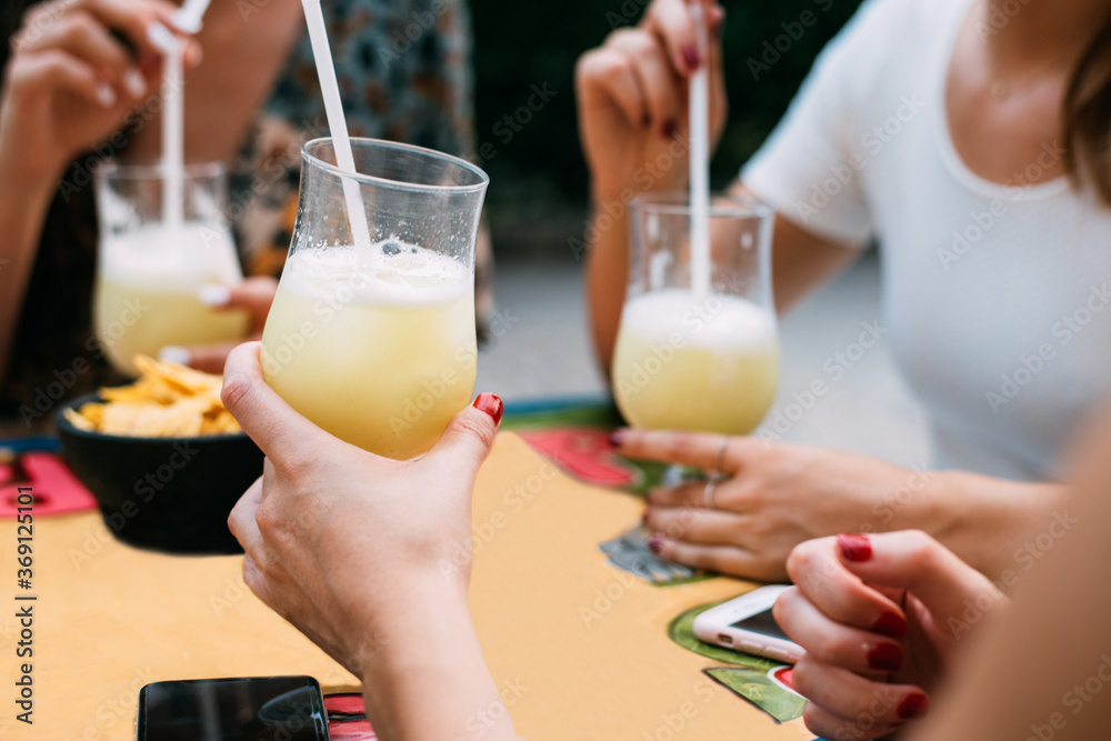 Happy Friends having lemonade drinks in a outdoors terrace