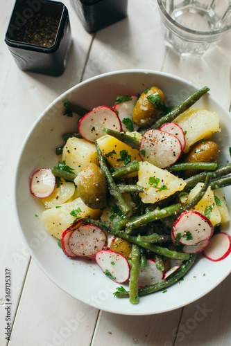 Vegan salad with potatoes green beans olives and radishes