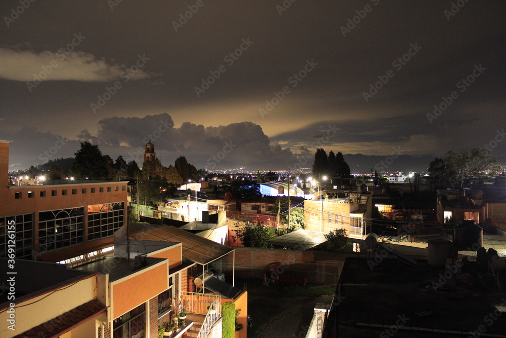 Anocheciendo en un pueblo mexicano y nubes de lluvia 