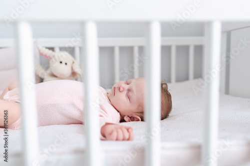 Cute newborn baby sleeping is her crib