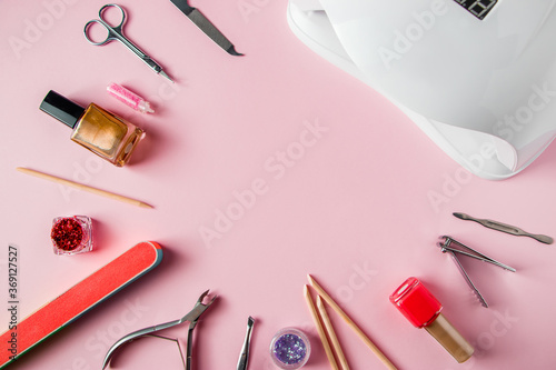 A set of tools for manicure and nail care on pink background. Workplace in a beauty salon. Place for text.