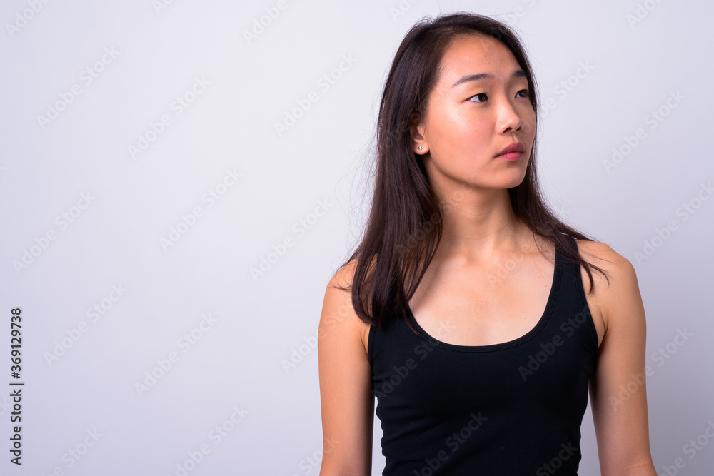 Portrait of young beautiful Asian woman against white background Portrait of young beautiful Asian woman against white background