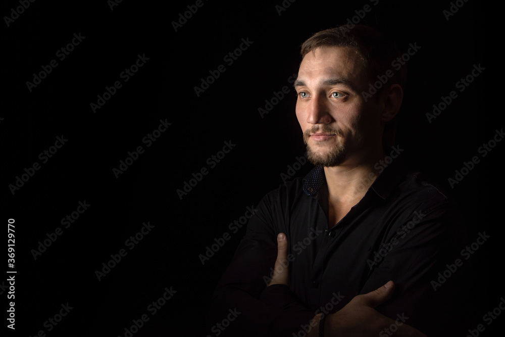 Closeup portrait of handsome man with a beard in black shirt. Isolated on black background Closeup portrait of handsome man with a beard in black shirt. Isolated on black background