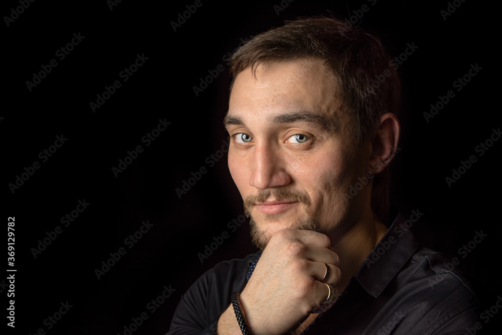 Closeup portrait of handsome man with a beard in black shirt. Isolated on black background Closeup portrait of handsome man with a beard in black shirt. Isolated on black background
