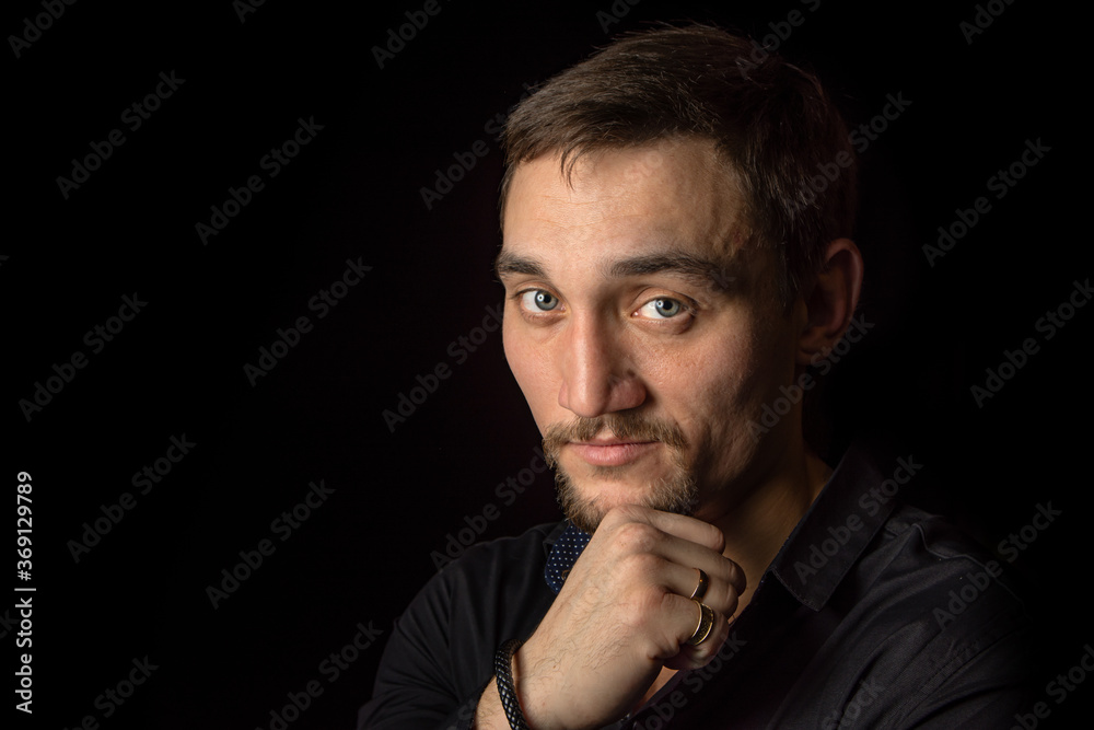 Closeup portrait of handsome man with a beard in black shirt. Isolated on black background Closeup portrait of handsome man with a beard in black shirt. Isolated on black background