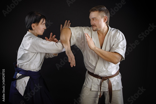 hand-to-hand man and woman fight on a black background. Asian vs European School. Training fight concept.