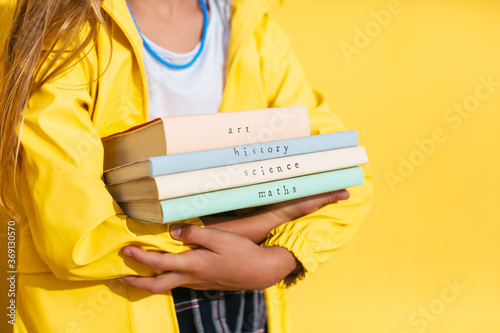 Crop girl with stack of textbooks