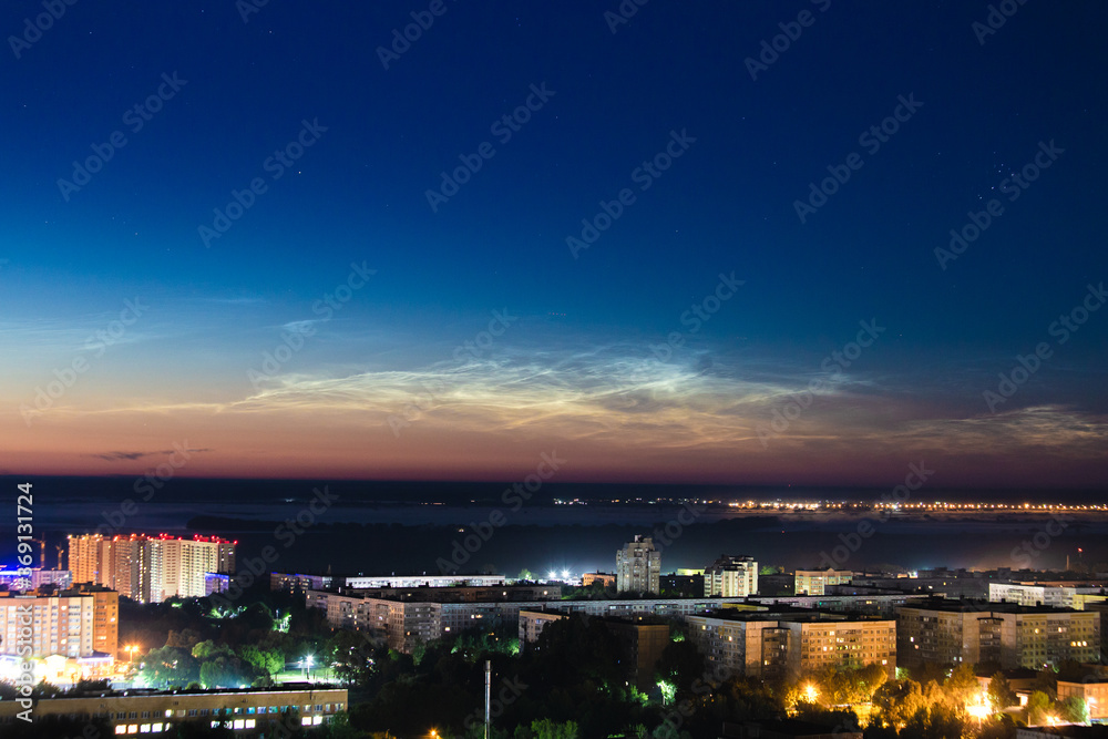 noctilucent clouds over night city