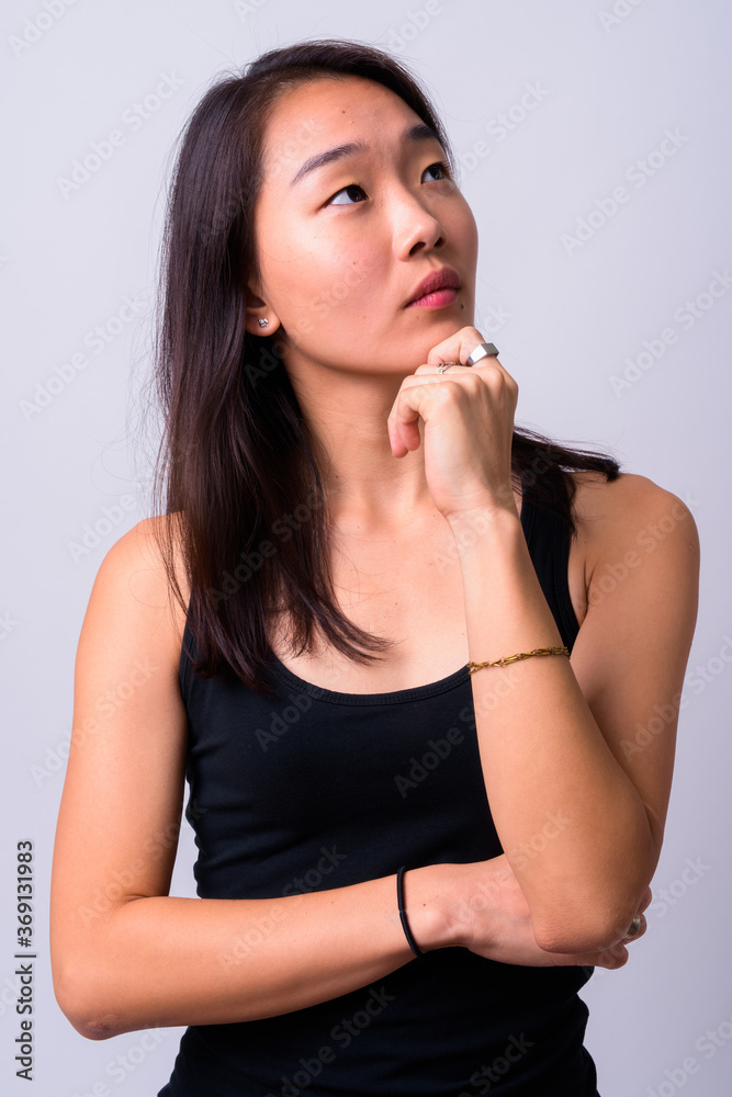 Portrait of young beautiful Asian woman against white background Portrait of young beautiful Asian woman against white background