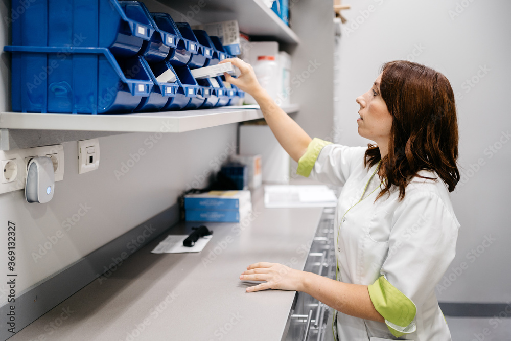 Pharmacist grabbing a medication from the warehouse Pharmacist grabbing a medication from the warehouse