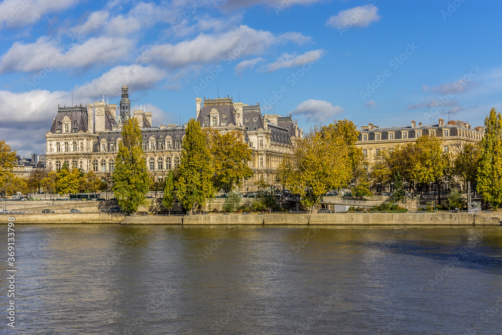 The picturesque embankments of the river Seine in autumn in Paris: buildings, trees and river. Paris, France.
