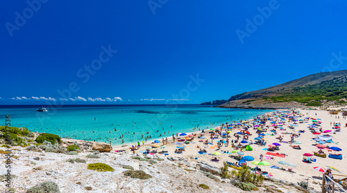 CALA MESQUIDA  MALLORCA  SPAIN - 19 July 2020  People enjoying beautiful sandy beach of on Mallorca  Mediterranean Sea  Spain.
