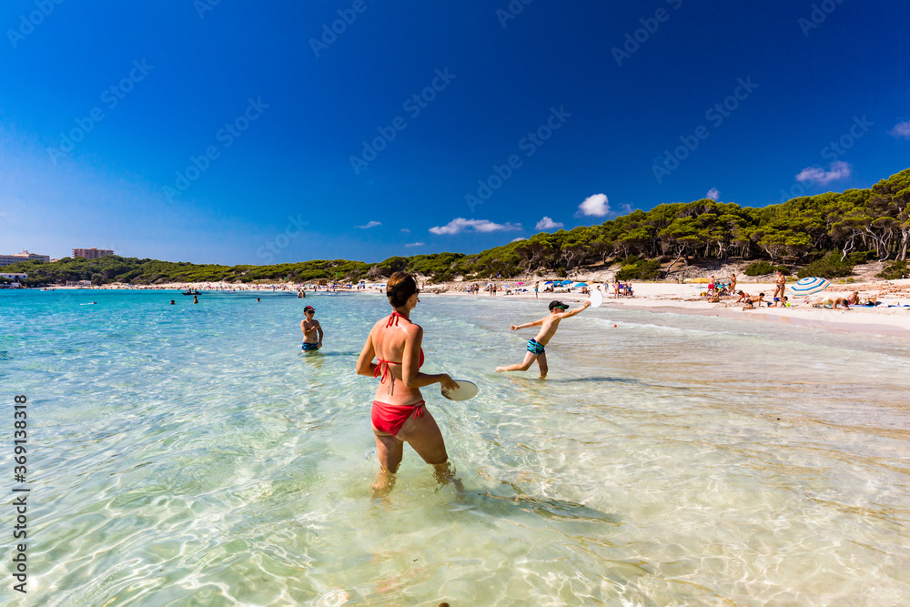 CALA AGULLA, MALLORCA, SPAIN - 21 July 2020: People enjoying summer on the popular beach on Mallorca, Balearic Islands. CALA AGULLA, MALLORCA, SPAIN - 21 July 2020: People enjoying summer on the popular beach on Mallorca, Balearic Islands.