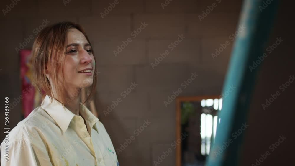 Young Girl Artist In Art Studio. Girl Paints Picture And Looks At Her Work With Pleasure. Young Girl Artist In Art Studio. Girl Paints Picture And Looks At Her Work With Pleasure.