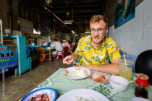 Obraz na płótnie Handsome caucasian man in local vietnamese restaurant w salonie