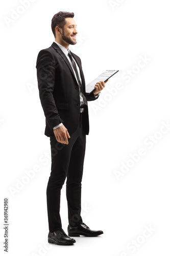 Elegant man in a black suit holding a clipboard