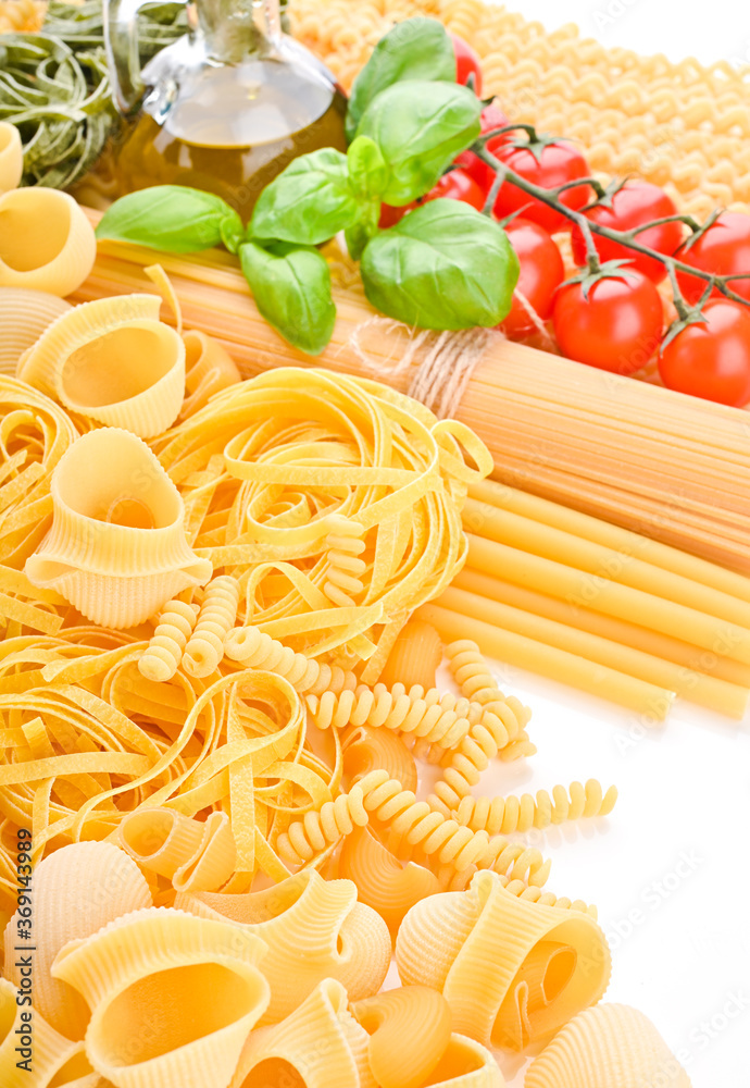 A group of different types of Italian pasta. Pasta with fresh tomatoes, basil and olive oil on light shabby rustic background, top view, border. Pasta with ingredients for cooking. Italian food