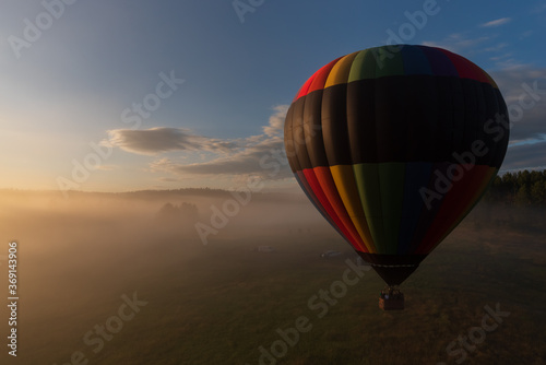 Hot air balloon lifting off on a foggy morning