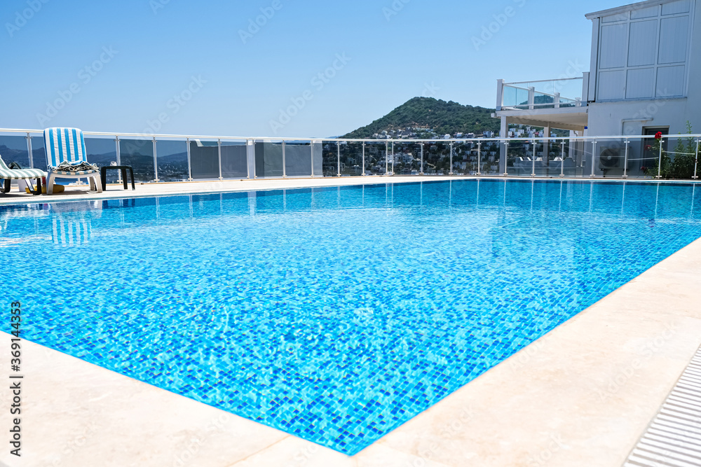 Swimming pool with turquoise color water at hotel or holiday village atsunny day