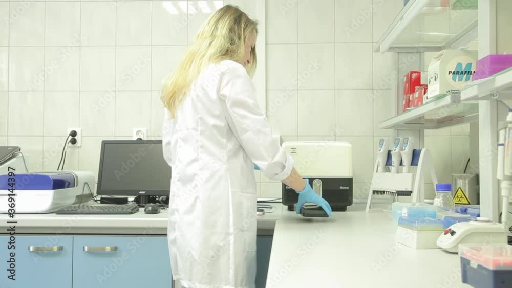 Lady in a white coat working in a laboratory. Lady in a white coat working in a laboratory.