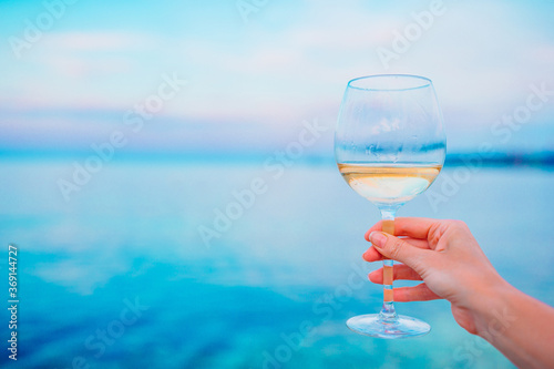 Glass of white wine on tropical beach