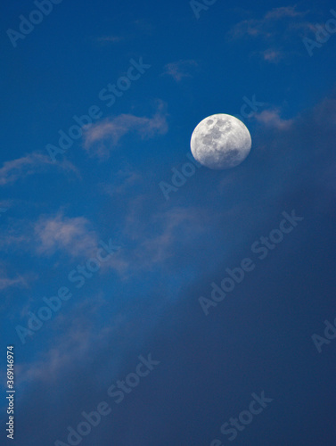 luna junto a nubes con un cielo azul 