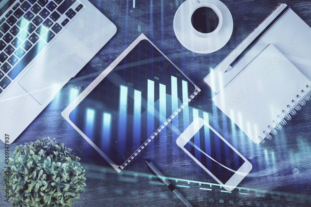 Naklejka premium Double exposure of forex chart hologram over desktop with phone. Top view. Mobile trade platform concept.