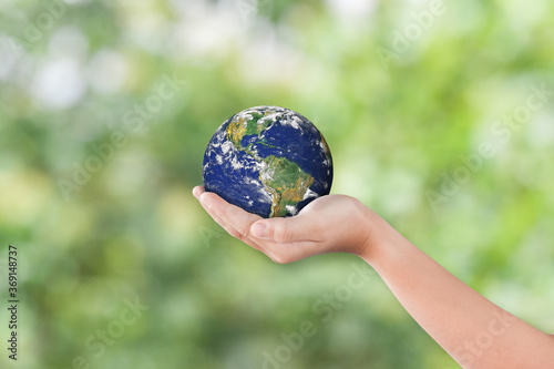 Fototapeta Naklejka Na Ścianę i Meble -  Environment day concept: Child hands holding earth over blurred green nature background. Elements of this image furnished by NASA