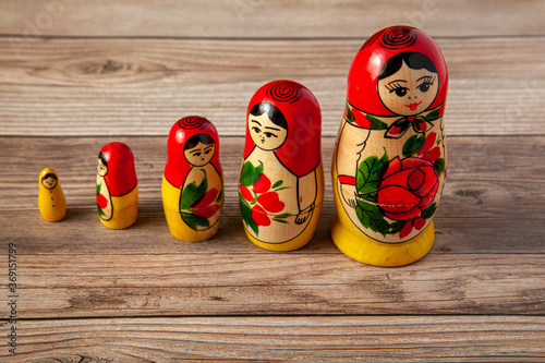 A line up of handmade Russian Matrushka dolls on wooden background. These folkloric women figurines are famous in Slavic countries and these toys are popular souvenirs for tourists visiting there.