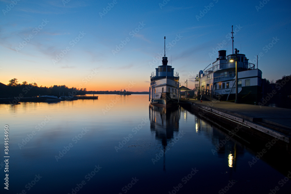 Water reflection of the steamship in the pier at twilight