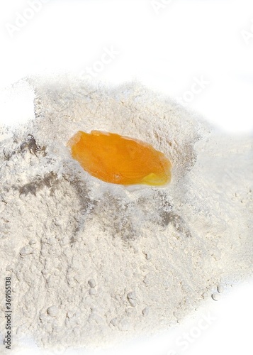 Chicken Egg Falling into Flour  against White Background