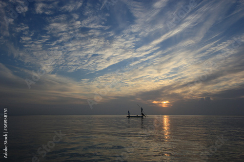 Distant fishermen pole their boat over shallows of Bear Cut off Key Biscayne, Florida on calm April morning.