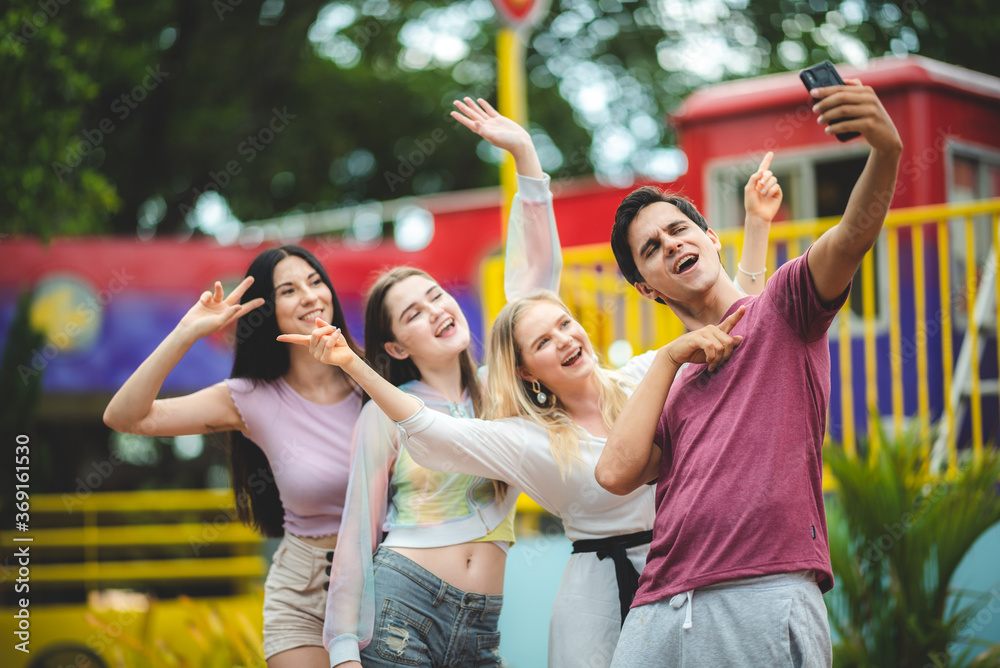 Group of happy best friends laughing and having fun at amusement park, holiday travel with friends concept - obrazy, fototapety, plakaty 