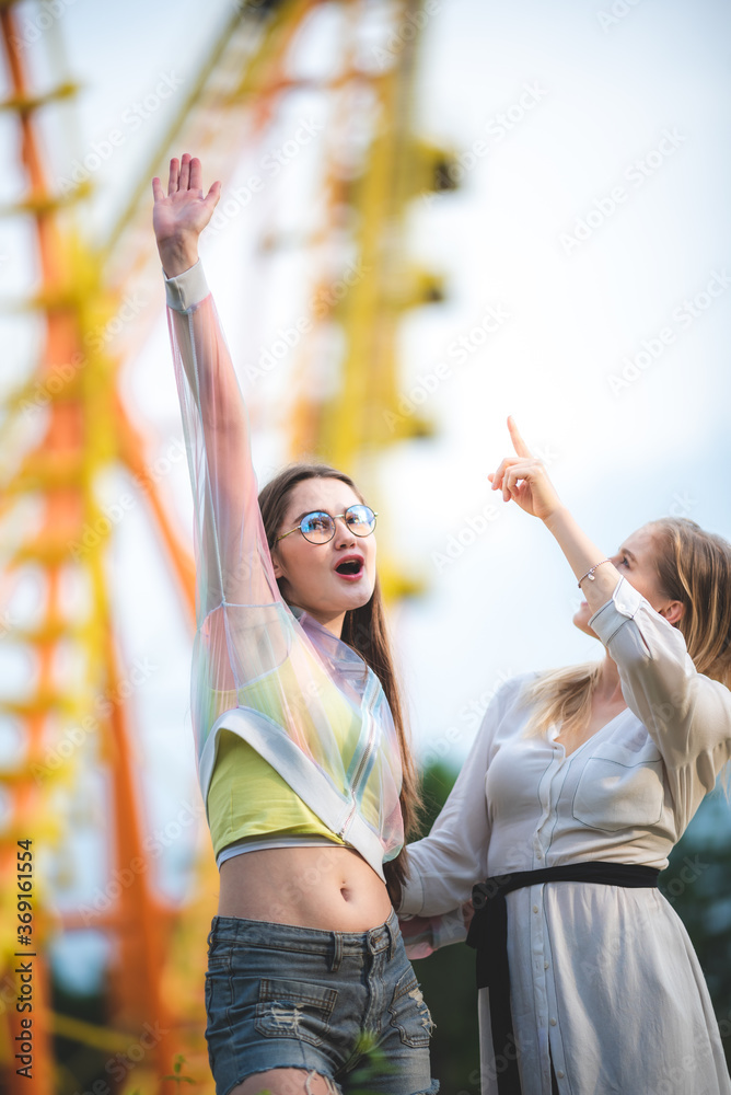 Group of happy best friends laughing and having fun at amusement park, holiday travel with friends concept