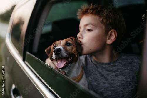 A young boy passenger in the car with the dog