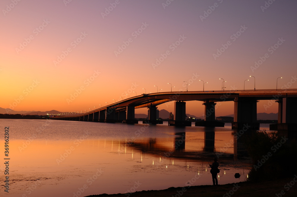 オレンジ色に染まってくる夜明けの琵琶湖畔です Stock Photo Adobe Stock