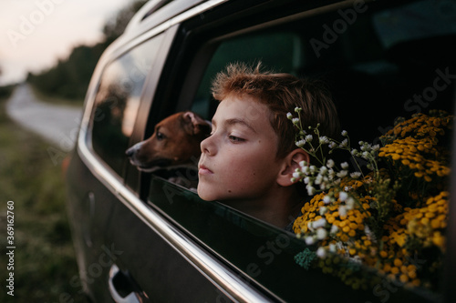 A young boy passenger in the car with the dog