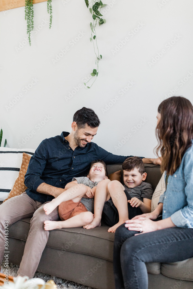 Young Family Laughing Together in Modern Home Young Family Laughing Together in Modern Home