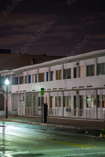 Photography Photo of an abandoned hotel building at night with street lights boarded up